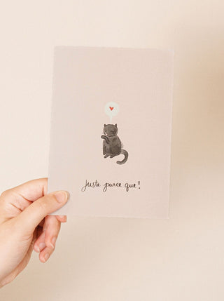 Carte de souhait Juste parce que Mimi & August, représentant un chat qui se lèche avec un cœur et l'inscription "Juste parce que !". Fabriquée au Canada, parfaite idée de cadeau pour femme. 