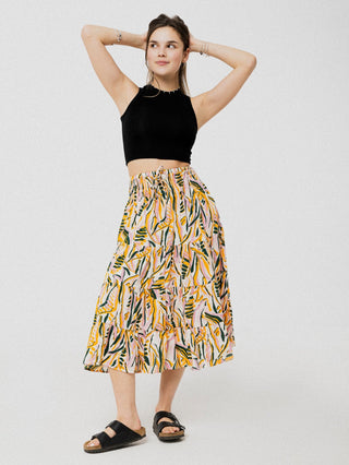 Jupe à taille élastique en dessous du genou ample et confortable à motif de feuilles rose pâle, jaune et noir. Designer québécois.