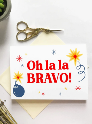 Carte de souhait fond blanc avec dessin de bombe et artifice inscrit: Oh la la BRAVO!. Parfait idée cadeau pour femme.