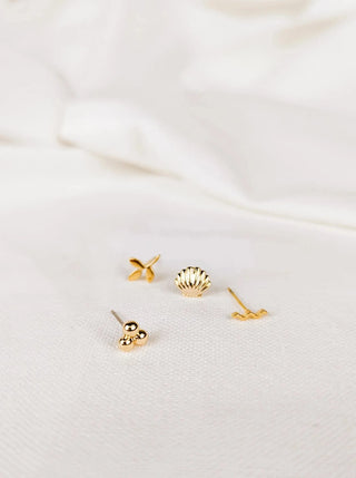 Ensemble de 4 boucle d'oreilles Tofino- or Mimi & August, représentant un coquillage, une vague, une feuille et des perles. Parfaite idée de cadeau pour femme.