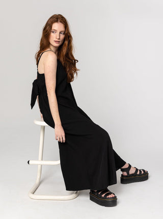 Combinaison longue, ample et confortable noire à bretelles ajustables avec une boucle dans le dos. Designer québécois.