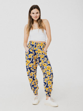 Pantalon marine à motif de fleurs jaune ample et confortable avec élastique aux chevilles et à la taille.