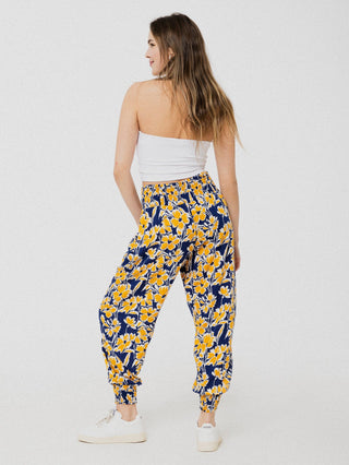 Pantalon marine à motif de fleurs jaune ample et confortable avec élastique aux chevilles et à la taille.