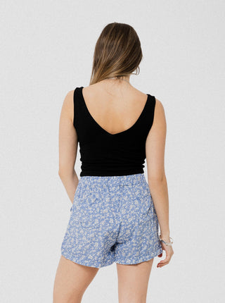 Short bleu avec petites fleurs blanches ample, léger et confortable avec élastique au dos et poches latérales. Designer québécois.