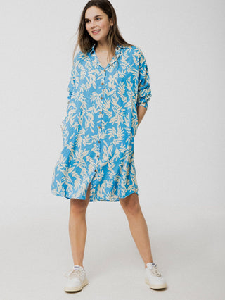 Robe d'été légère, ample et confortable bleu avec motif de feuilles blanches. Elle comporte une boutonnière et à des manches longues. Designer québécois.
