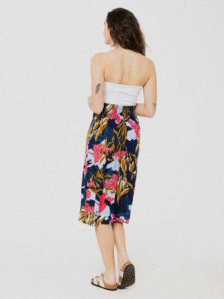 Jupe droite ample et confortable avec légère ouverture à l'avant marine à motif de fleurs tropicales rose et bleu. Taille élastique au dos. Designer québécois.