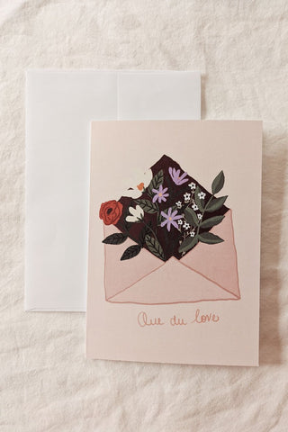 MIMI & AUGUST Carte de Souhait - Que du Love, représentant une enveloppe remplie de fleurs avec l'inscription "Que du love". Parfaite idée de cadeau pour femme.